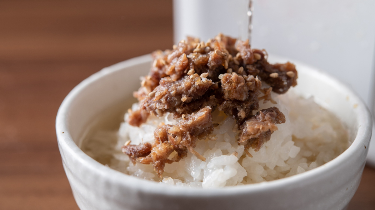 宮城県産米「ひとめぼれ」に牛たんのしぐれ煮をのせ、特製だし汁をかけている様子