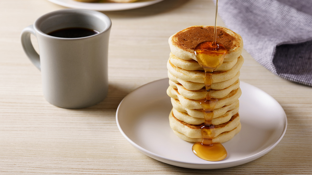 在堆疊的蛋糕煎餅上澆上楓糖漿的樣子