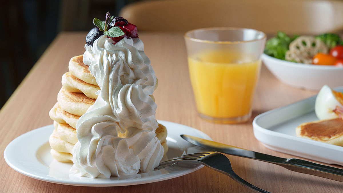 ホイップクリームとフルーツを沿えたデザート風パンケーキと、サラダやベーコンを沿えたメインディッシュ風パンケーキ