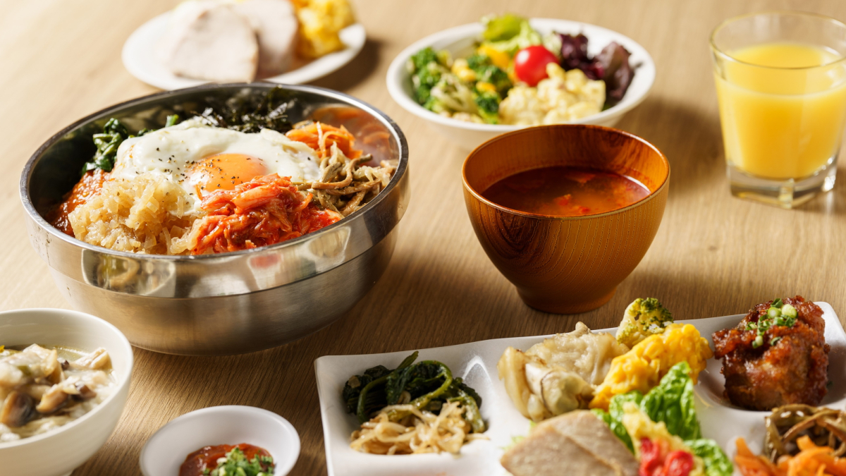 韓国料理のビビンバを含む多様なビュッフェメニューとサラダ、スープが並んだ写真