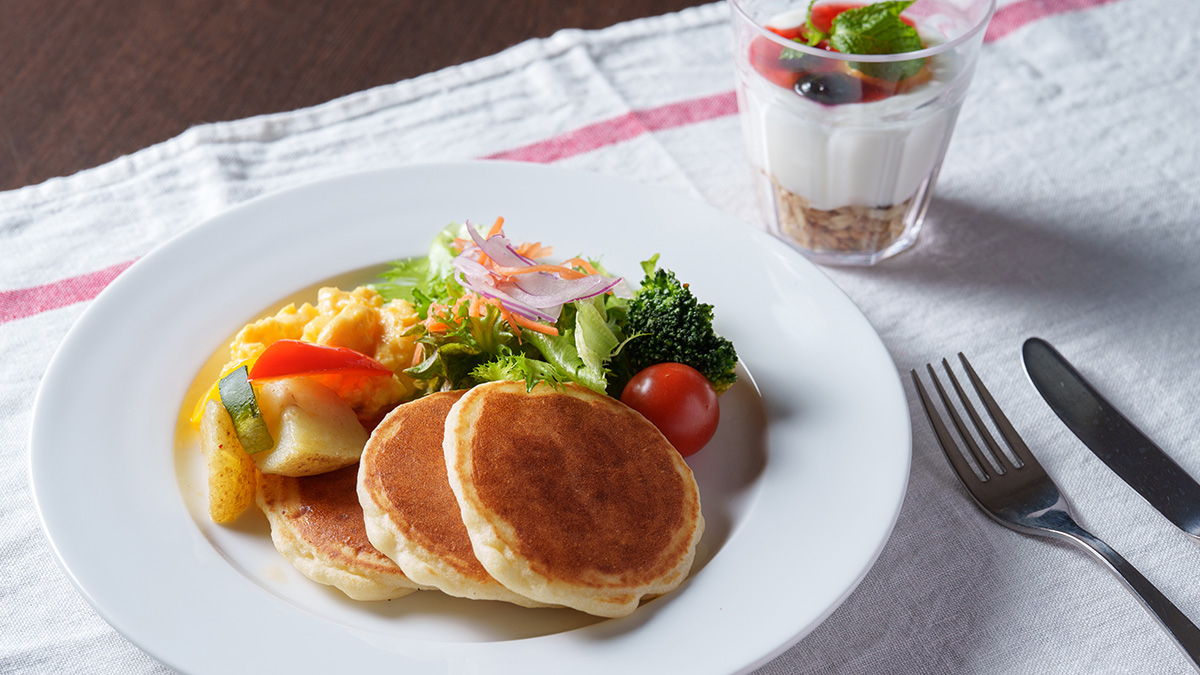 Pancakes Arranged as a Main-Style Dish with Scrambled Eggs and Salad