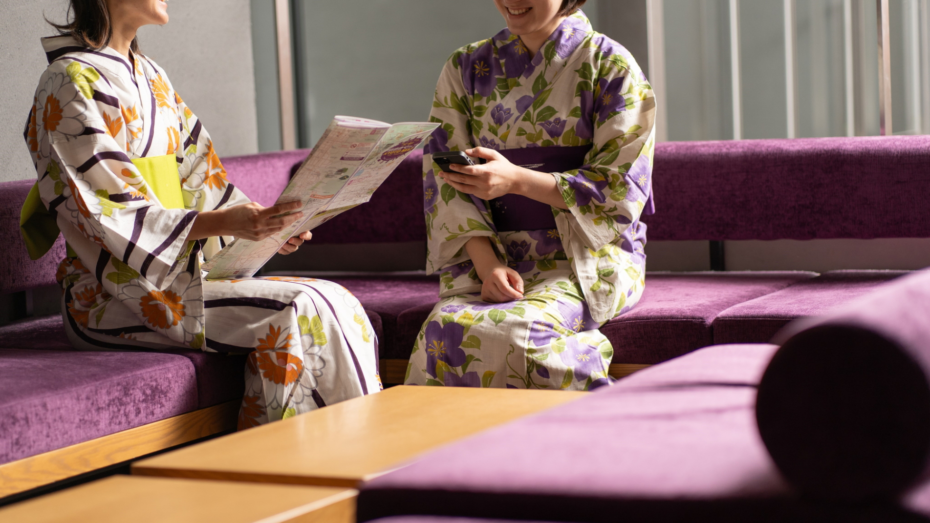 Two women in yukata chatting in the lobby