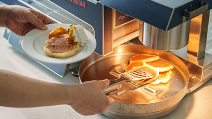 パンケーキマシンからパンケーキを取る様子