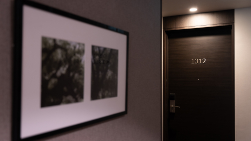 客室フロア廊下に飾られたアートパネルと客室扉の写真